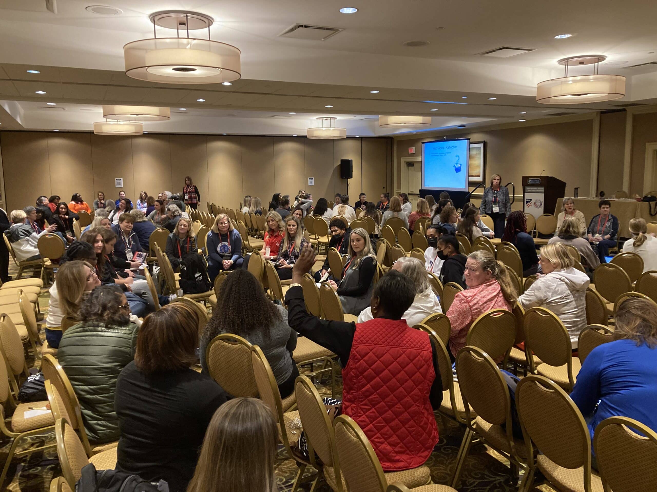 A large room of attendees seated for a conference session.