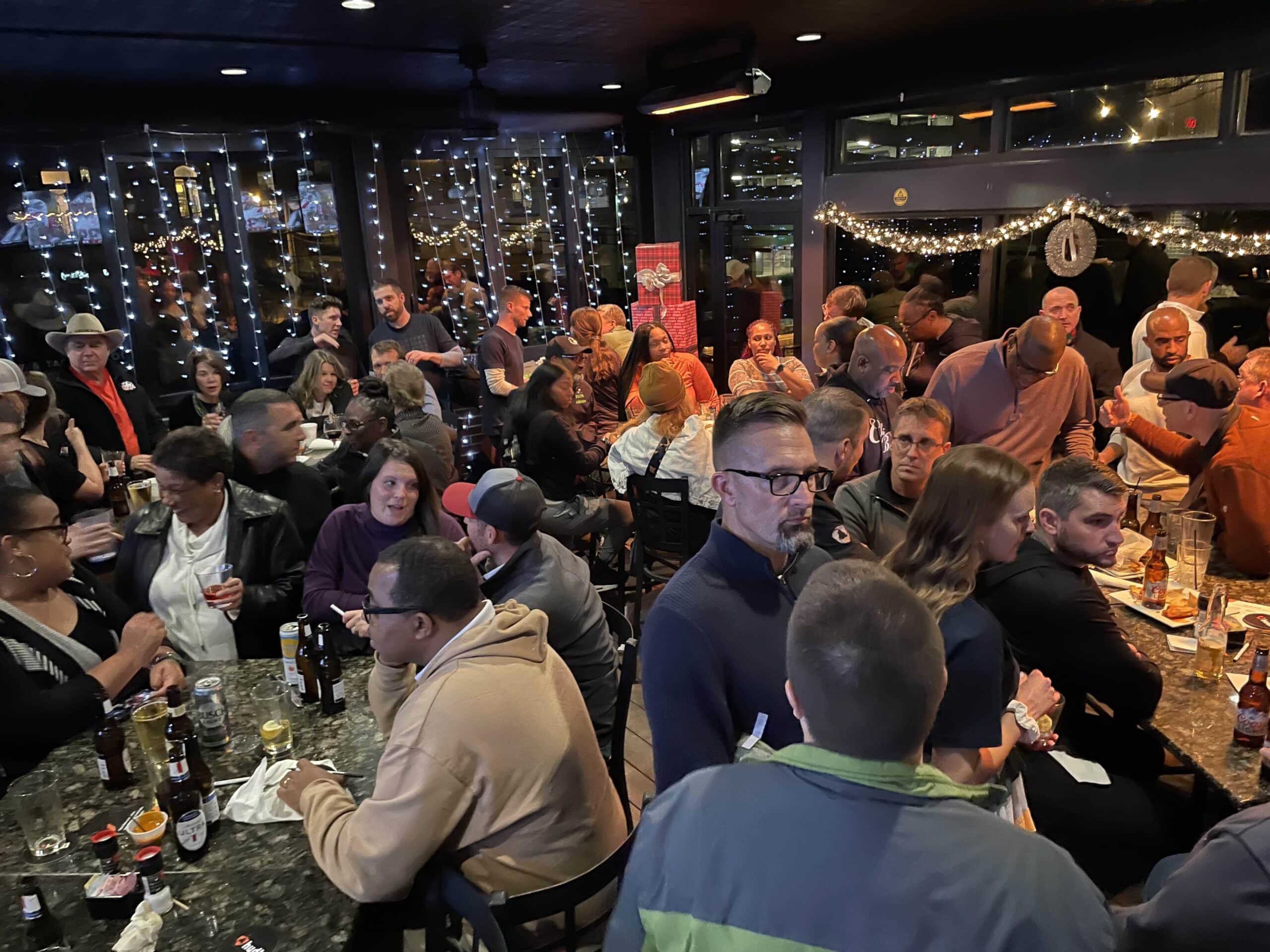 Attendees talking in small groups at an evening gathering after a conference day.